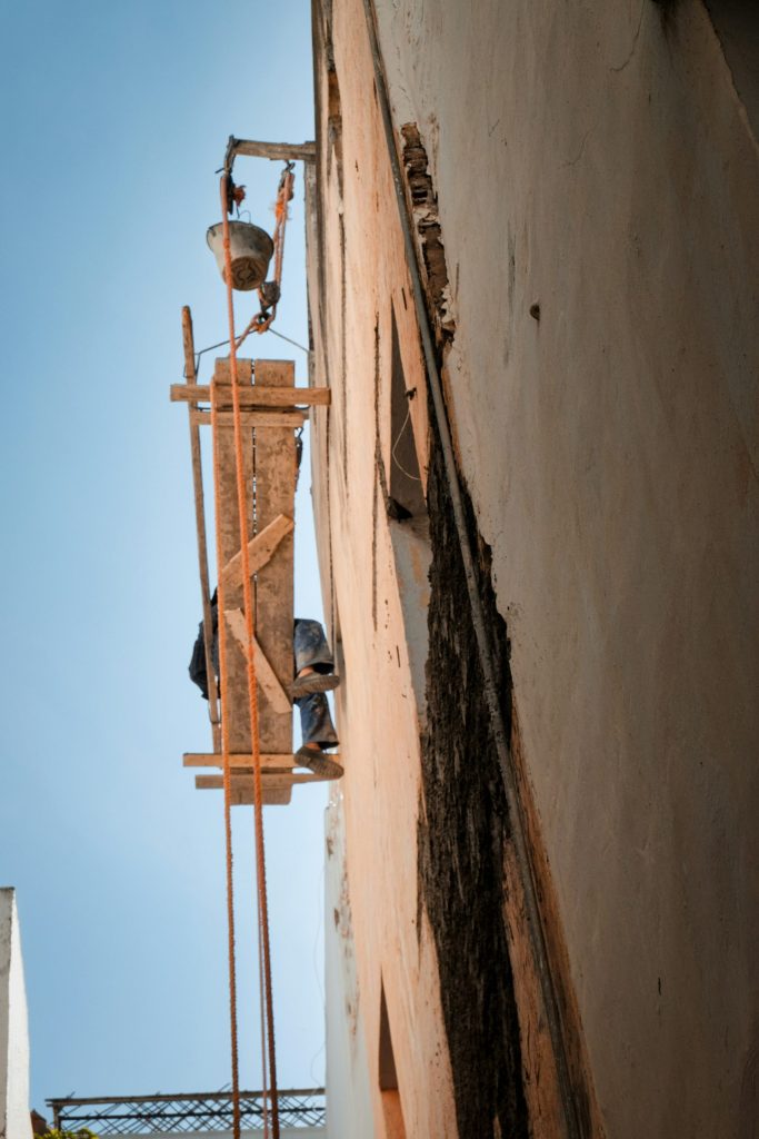 Arbeiter auf Gerüsten malen alte Gebäudefassade